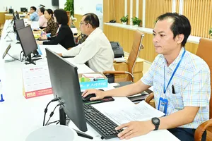 Cán bộ công chức làm việc tại Bộ phận tiếp nhận và trả kết quả của quận 6. Ảnh: VIỆT DŨNG 