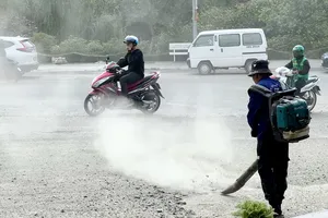 Công nhân sử dụng máy thổi công suất lớn thổi bụi vào người đi đường