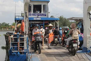 Nhân viên bến đò An Sơn, TPHCM phát áo phao cho khách đi phà. Ảnh: XUÂN TRUNG