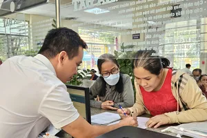 Ông Trương Văn Sự, thành viên tổ địa bàn tại Trung tâm Phục vụ hành chính công phường Gò Vấp, TPHCM hướng dẫn người dân thực hiện thủ tục hành chính. Ảnh: NGÔ BÌNH