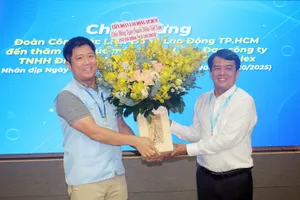 Đồng chí Bùi Thanh Nhân (bìa phải) tặng hoa đến đại diện lãnh đạo Công ty TNHH Điện tử Samsung HCMC CE Complex 