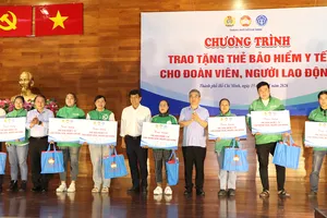 Phó Bí thư Thành ủy TPHCM Nguyễn Phước Lộc (giữa) trao thẻ BHYT và quà đến người lao động khó khăn