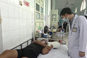 BS Ngô Hồng Phúc, Trưởng khoa Bỏng - Chỉnh trực, Bệnh viện Nhi đồng 2, thăm khám cho bệnh nhi bỏng nặng do pháo nổ. Ảnh: MINH KHUÊ