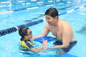 Huấn luyện viên hướng dẫn trẻ em tập bơi tại Trung tâm Thể thao dưới nước TPHCM. Ảnh: DŨNG PHƯƠNG