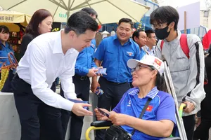 Đồng chí Nguyễn Minh Triết tặng quà, tiễn người lao động về quê sáng 11-2. Ảnh: THÁI PHƯƠNG