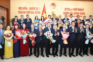 Bí thư Thành ủy Đà Nẵng tặng hoa chúc mừng Chủ tịch, Phó Chủ tịch và các ủy viên UBND TP Đà Nẵng. Ảnh: XUÂN QUỲNH