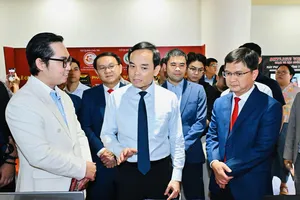 Bí thư Thành ủy TPHCM Trần Lưu Quang và Phó Chủ tịch UBND TPHCM Nguyễn Mạnh Cường tham quan gian hàng công nghệ tại lễ ra mắt Công ty cổ phần Quỹ đầu tư mạo hiểm TPHCM, ngày 17-4. Ảnh: VIỆT DŨNG)