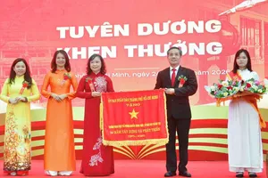 Ông Nguyễn Kế Toại, Phó Giám đốc Sở GD-ĐT TPHCM, trao cờ thi đua của UBND TPHCM tặng Trường THPT Nguyễn Trung Trực