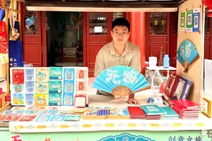 Lý Trạch Di bán các sản phẩm do chính anh thiết kế trước cửa hàng văn hóa và sáng tạo của mình tại huyện Vũ Đế. Ảnh: THX