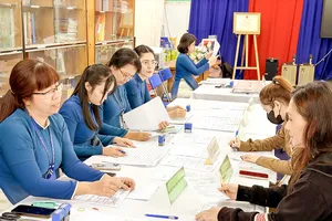 Giáo viên Trường Tiểu học Âu Dương Lân (phường Chánh Hưng, TPHCM) hướng dẫn phụ huynh hoàn thiện hồ sơ đăng ký tuyển sinh đầu cấp. Ảnh: HOÀNG HÙNG