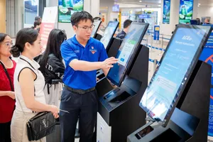 Hướng dẫn hành khách sử dụng kiosk check-in bằng sinh trắc học tại sân bay Nội Bài. Ảnh: HÀ PHAN