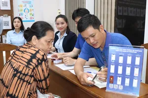 Cán bộ Trung tâm Phục vụ hành chính công phường Xóm Chiếu hỗ trợ người dân thực hiện thủ tục hành chính. Ảnh: THÁI PHƯƠNG