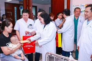 Chủ tịch Ủy ban Trung ương MTTQ Việt Nam Bùi Thị Minh Hoài trao quà cho các cháu thiếu nhi đang điều trị tại Bệnh viện Nhi Trung ương. Ảnh: QUANG VINH