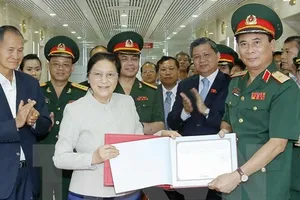 Chủ tịch Quốc hội Lào Pany Yathotou viết lưu niệm tại Binh đoàn 11 (Bộ Quốc phòng). Ảnh: TTXVN