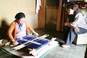 Nghệ nhân Cơ Liêng K’Phước bên khung dệt và Rơ Ông K’Ương