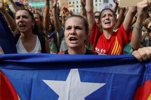 Một phụ nữ cầm cờ ly khai của Catalonia trên đường phố Barcelona hôm 2/10. Ảnh: Reuters.