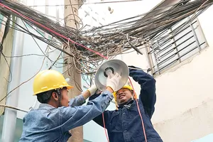 Đoàn viên thanh niên ngành điện thi công lắp mới  đèn chiếu sáng tuyến hẻm