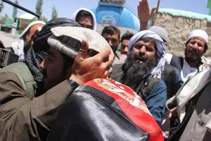 Chiến binh Taliban và người Afghanistan ôm nhau tại Ghazni ngày 16-6. Ảnh: CNN