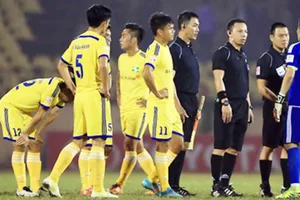 Thủ môn Nguyên Mạnh (bìa phải) và các cầu thủ SLNA phản ứng tổ trọng tài. Ảnh: Minh Hoàng