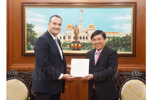 Chủ tịch UBND TPHCM Nguyễn Thành Phong tặng quà lưu niệm cho tân Tổng lãnh sự Canada Kyle Nunas. Ảnh: hcmcpv