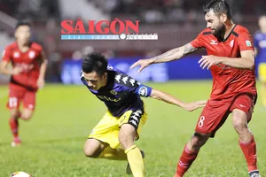 Văn Quyết (10, Hà Nội) che bóng trước Paulo Fernandes của TP Hồ Chí Minh. Ảnh: NGUYỄN NHÂN