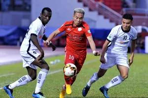 Phi Sơn (áo đỏ, CLB TPHCM) đi bóng trước hàng phòng ngự SHB Đà Nẵng. Ảnh: NGUYỄN NHÂN