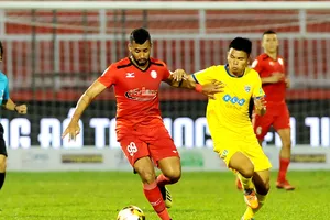 Chaves Santos (99, TPHCM) tranh bóng với Văn Thắng của FLC Thanh Hoa. Ảnh: NGUYỄN NHÂN