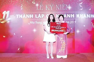 Bà Ninh Thị Quỳnh Thơm - Quyền Giám đốc SCB Khánh Hòa (áo trắng) trao tặng 50 triệu đồng cho đại diện Quỹ Khuyến học khuyến tài Khánh Hòa - Tiến sĩ Bùi Thị Hồng Tiến - Giám đốc Quỹ Khuyến học khuyến tài Khánh Hòa (áo dài)