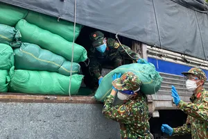 Bộ đội bốc dỡ gạo, thực phẩm, nhu yếu phẩm cung ứng đến các phường tại quận 6, sáng 28-8. Ảnh: CAO THĂNG