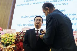 Ông Olivier Brochet, Đại sứ Cộng hòa Pháp tại Việt Nam, thay mặt Tổng thống Cộng hòa Pháp trao Huân chương Công trạng Quốc gia, tước hiệu Hiệp sĩ cho GS-TS Nguyễn Vũ Quốc Huy. Ảnh: TTXVN