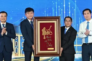 Thứ trưởng Bộ Xây dựng Nguyễn Tường Văn và Phó Chủ tịch UBND TPHCM Bùi Xuân Cường trao tặng khánh chữ vàng đến tập thể SAWACO. Ảnh VIỆT DŨNG