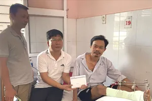 Đại diện Báo SGGP trao tiền cho anh Lê Văn Toán