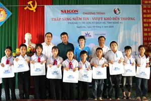 Phó Tổng Biên tập Báo SGGP Nguyễn Ngọc Anh và đại diện Công ty TNHH Dược phẩm Helios trao học bổng và quà cho các em học sinh Trường Tiểu học Mỹ Sơn