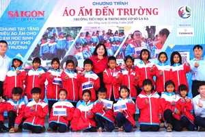 Phó Tổng Biên tập Báo SGGP Bùi Thị Hồng Sương cùng đại diện nhà tài trợ, Ban Giám hiệu Trường Tiểu học và THCS La Dạ trao học bổng cho các em học sinh