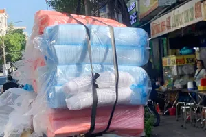 Chiếc xe máy chở hàng cồng kềnh, quá khổ, di chuyển nhanh trên đường