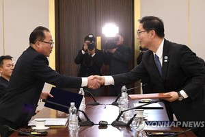 South Korean and North Korean chief delegates shake hands after agreeing at talks on Jan. 17, 2018, to march together under a unified flag at the opening ceremony of the PyeongChang Olympics. (Yonhap)