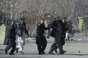 Volunteers help injured men at the scene where an ambulance exploded in front of the old Ministry of Interior building in Kabul on Saturday. — AFP/VNA Photo 