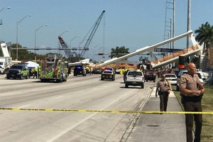 Police block a road near a newly installed pedestrian bridge that collapsed in Miami. – AFP/VNA Photo