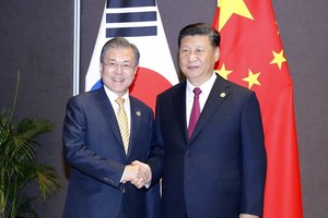 South Korean President Moon Jae-in (L) shakes hands with Chinese President Xi Jinping before their talks in Papua New Guinea on the sidelines of the Asia Pacific Economic Cooperation (APEC) forum on Nov. 17, 2018. (Yonhap)