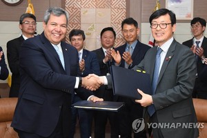 This photo provided by the Ministry of Economy and Finance shows Vice Minister Lee Ho-seung (R) shaking hands with Dante Mossi, executive president of the Central American Bank for Economic Integration, during a signing ceremony at the government complex 