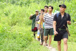 Xã đội trưởng Đinh Tân (người đi đầu) và các thành viên an ninh xã tuần tra bảo vệ rừng