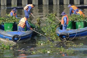 Vớt rác làm sạch môi trường không để dòng chảy bị tắc nghẽn. Ảnh: Thành Trí