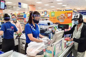 Nón chống dịch được nhân viên siêu thị sử dụng để tự bảo vệ mình khi tiếp xúc với khách hàng