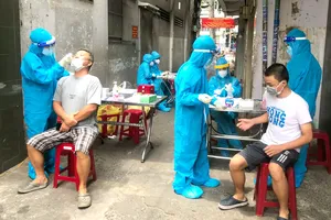 Anh Trần Bình An, sinh viên Trường Đại học Y khoa Phạm Ngọc Thạch (ngoài cùng bên trái) lấy mẫu xét nghiệm cho người dân