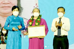 Trưởng Ban Dân vận Thành ủy TPHCM Nguyễn Hữu Hiệp chúc mừng một người con hiếu thảo được tuyên dương. Ảnh: THÁI PHƯƠNG