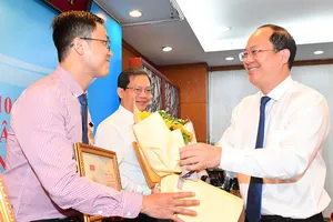 Phó Bí thư Thành ủy TPHCM Nguyễn Hồ Hải tặng kỷ niệm chương “Vì sự nghiệp dân vận”. Ảnh: VIỆT DŨNG