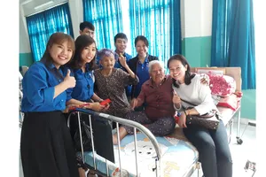 Đoàn công tác của Báo SGGP đến từng giường lì xì  mừng tuổi các cụ ở Trung tâm Nuôi dưỡng bảo trợ người bại liệt Thạnh Lộc