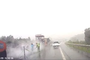 Thi công sửa chữa đường cao tốc Nội Bài - Lào Cai dưới trời mưa to ngày 9-5. Ảnh: Báo Tiền Phong
