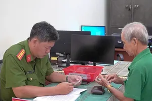 Cán bộ Công an phường Tân Thành thực hiện thủ tục đăng ký xe cho người dân có nhu cầu ngay tại trụ sở phường. Báo Cà Mau