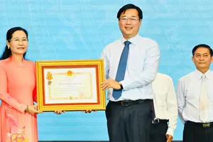 Phó Bí thư Thường trực Thành ủy TPHCM Lê Quốc Phong trao Huân chương Độc lập hạng ba đến đồng chí Nguyễn Thị Lệ, nguyên Phó Bí thư Thành ủy, nguyên Chủ tịch HĐND TPHCM. Ảnh: VIỆT DŨNG